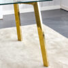 71 * 35.4 inch rectangular dining table. The transparent tempered glass tabletop is paired with golden 7-shaped metal table legs, showcasing a minimalist texture. Suitable for various places.