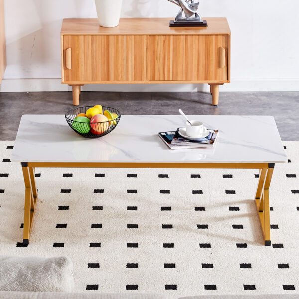 7890bede13f540e191034ceebc5e942d_6d0984da3cf4d5561974706343272103 A coffee table made of rock slab material, with a smooth and natural surface that complements the modern design of the golden metal legs, making it suitable for living rooms of all sizes.47*23.6
