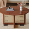 A natural and elegant deep red wooden coffee table with artificial rattan decorations, perfect for a fashionable living room and comfortable tea drinking time
