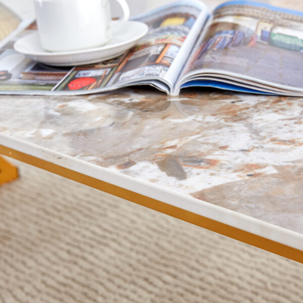 dd34d3ce140c45908542c77341cdb1db_4aba624af2efc18da2ac4fbba11db333 A coffee table is made of rock slab material, with a natural and smooth marble pattern on the surface, which complements the modern design of the golden metal legs and adds a touch of fashion.47*23.6