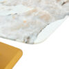 A modern minimalist dining table. Imitation marbled glass tabletop. Gold MDF table legs for kitchen and living room